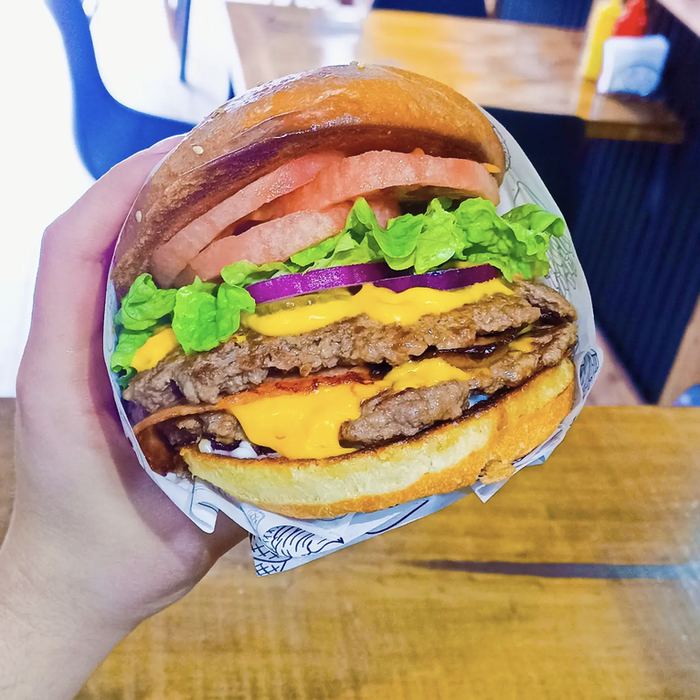 Fotografía de una hamburguesa de Ruta Central con queso y vegetales